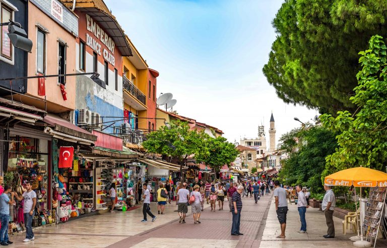 Tourists shop in stores along a bust street in Kusadasi Turkey 768x492